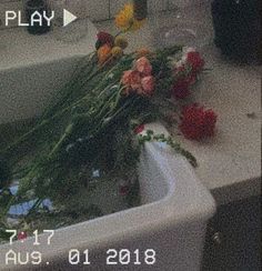 flowers are sitting on the edge of a sink