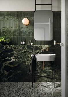 a white sink sitting under a mirror next to a wall mounted faucet in a bathroom