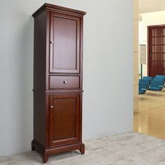 a tall wooden cabinet sitting in the corner of a room next to a blue chair