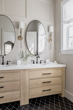 a bathroom with two sinks and three mirrors