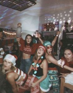 a group of young women standing next to each other in front of a christmas tree