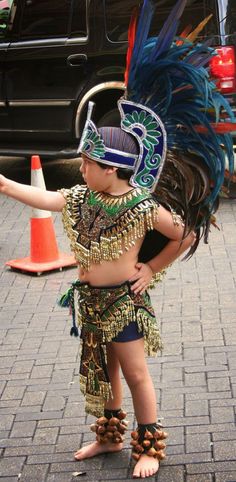 a young boy dressed in costume standing next to an orange cone