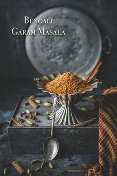 an image of some food in a bowl with spoons and spices on the side