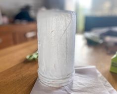 a glass filled with water sitting on top of a wooden table