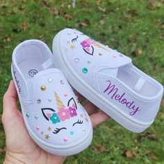 "Just as shown but with your child's name on the sides in purple. Everything about these shoes is sparkly and glittery. My designs and bling stays put! She will love these and you will too!  To visit my entire etsy shop and see all 200 of my items, please click here: cloversaigestudio.etsy.com Shoe measurements from heel to toe on soles of shoes: 5/6= 6\" 7/8= 6 3/4\" 9/10= 7\" 11/12= 7 3/4\"" Unicorn Birthday Shoes, Dyi Decoupage Shoes, Name Slip, Canvas Shoes Diy, Unicorn Shoes, Bedazzled Shoes, Painted Shoes Diy, Painted Canvas Shoes, Diy Sneakers