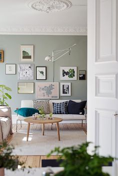 a living room filled with lots of furniture and pictures on the wall above it's coffee table