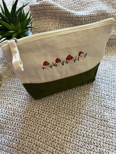 a small bag with mushrooms on it sitting next to a potted succulent plant