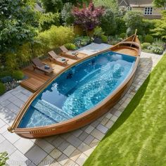 a wooden boat sitting on top of a lush green field next to a swimming pool