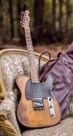 an old guitar sitting on top of a chair