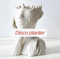 a white statue holding a sign that says disco planter