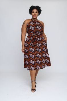 RD Basic This versatile dress is from the Ray Darten Basic line (RD Basic), the elegant African print dress could be worn to a wedding, a brunch with friends or worn during that dream vacation of yours. It has small cut-outs by the sides of the waist, that could be covered with a belt if preferred (belt included and see slide 4 for a picture) 100% cotton wax Halter neck Sleeveless Self-tie belt Elastic waist 2 cut-outs at the waist 2 sided pockets Back zipper Unlined A-line dress Color: Brown Th Vacation A-line Midi Dress With Tie Back, Brown A-line Midi Dress For Vacation, Beach Knee-length Dress With Tie Back, Printed Midi Sleeveless Dress For Vacation, Beach A-line Midi Dress With Tie Back, A-line Tie Back Midi Dress For Beach, A-line Midi Dress With Tie Back For Beach, Elegant Brown Sleeveless Dress For Beach, Fitted Tie Waist Dress For Vacation