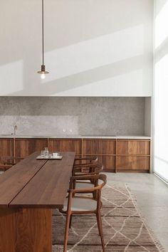 a large wooden table sitting in the middle of a room with lots of chairs around it