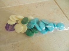 a plastic bag filled with blue, green and white candies on top of a counter