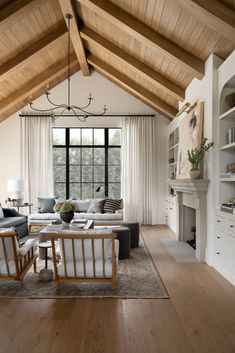 a living room filled with furniture and a fire place in front of a large window