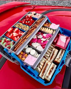 an open car trunk filled with lots of different types of food in it's trays