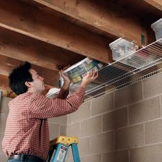 a man is working on the ceiling in his garage