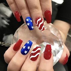 a woman's hands with red, white and blue nails