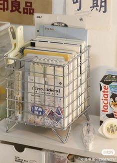 a metal basket filled with files and folders on top of a shelf next to other office supplies