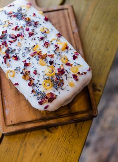 a piece of cake sitting on top of a wooden tray covered in white frosting