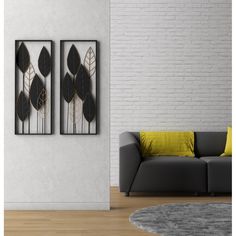 a living room with two black and white art pieces on the wall next to a gray couch