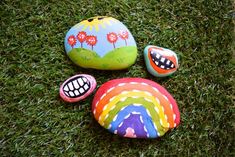 three painted rocks sitting on top of green grass