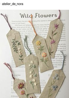 four bookmarks with flowers on them are sitting on top of an open book page