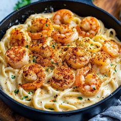 pasta with shrimp and parmesan cheese in a skillet on a wooden table