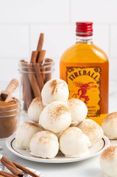 a white plate topped with marshmallows next to a bottle of booze