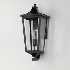 an old fashioned black wall light against a white wall