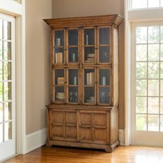 an old wooden bookcase with glass doors in a living room