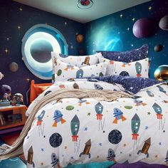 a bed room with a neatly made bed and space themed wallpaper