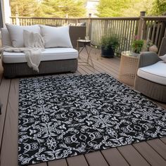 a black and white rug sitting on top of a wooden deck