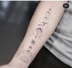 a person with a tattoo on their arm that has planets and stars all over it