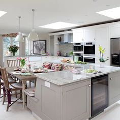 a large kitchen with an island in the middle and lots of counter space on one side