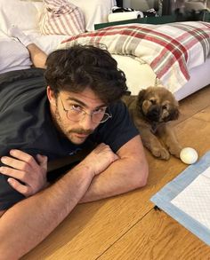 a man laying on the floor with his dog