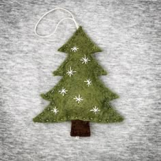 a felt christmas tree ornament hanging on a t - shirt