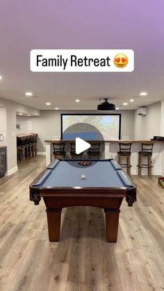 a room with a pool table and a projector screen in the background that says family retreat