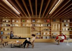 two people are sitting in chairs and reading books