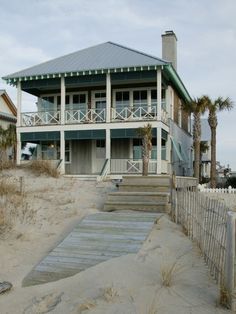 a house on the beach with stairs leading up to it