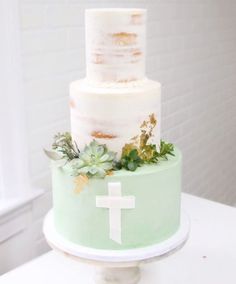 a white and green cake with a cross on top