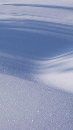 a person riding skis down a snow covered slope in the middle of the day