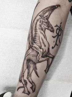 a man's arm with a dragon tattoo on it