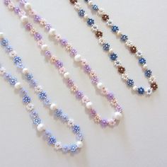 three strands of pearls and beads on a white surface