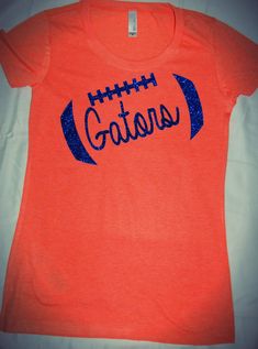 an orange shirt with blue glitters on it that says, go titans in front of a football