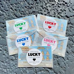 four lucky stickers sitting on top of a stone surface with the words lucky printed on them