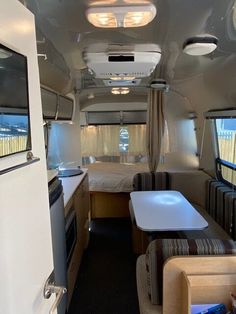 the interior of a camper with couches and tables