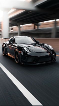 a black sports car driving down the road