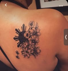 a woman's back tattoo with flowers on it