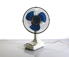 a blue and white fan sitting on top of a table