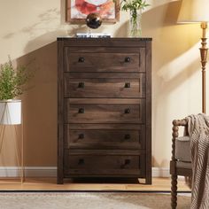 a wooden dresser sitting in a living room next to a lamp and painting on the wall